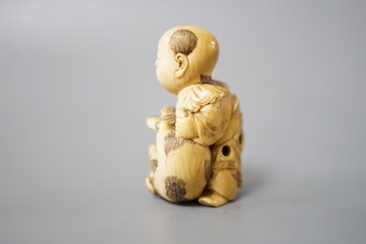 A Japanese ivory netsuke of boy and puppy, Meiji period, signed 4cm